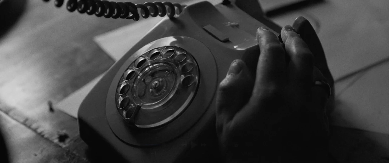 Black-and-white close-up of a rotary phone from Answer The Telephone