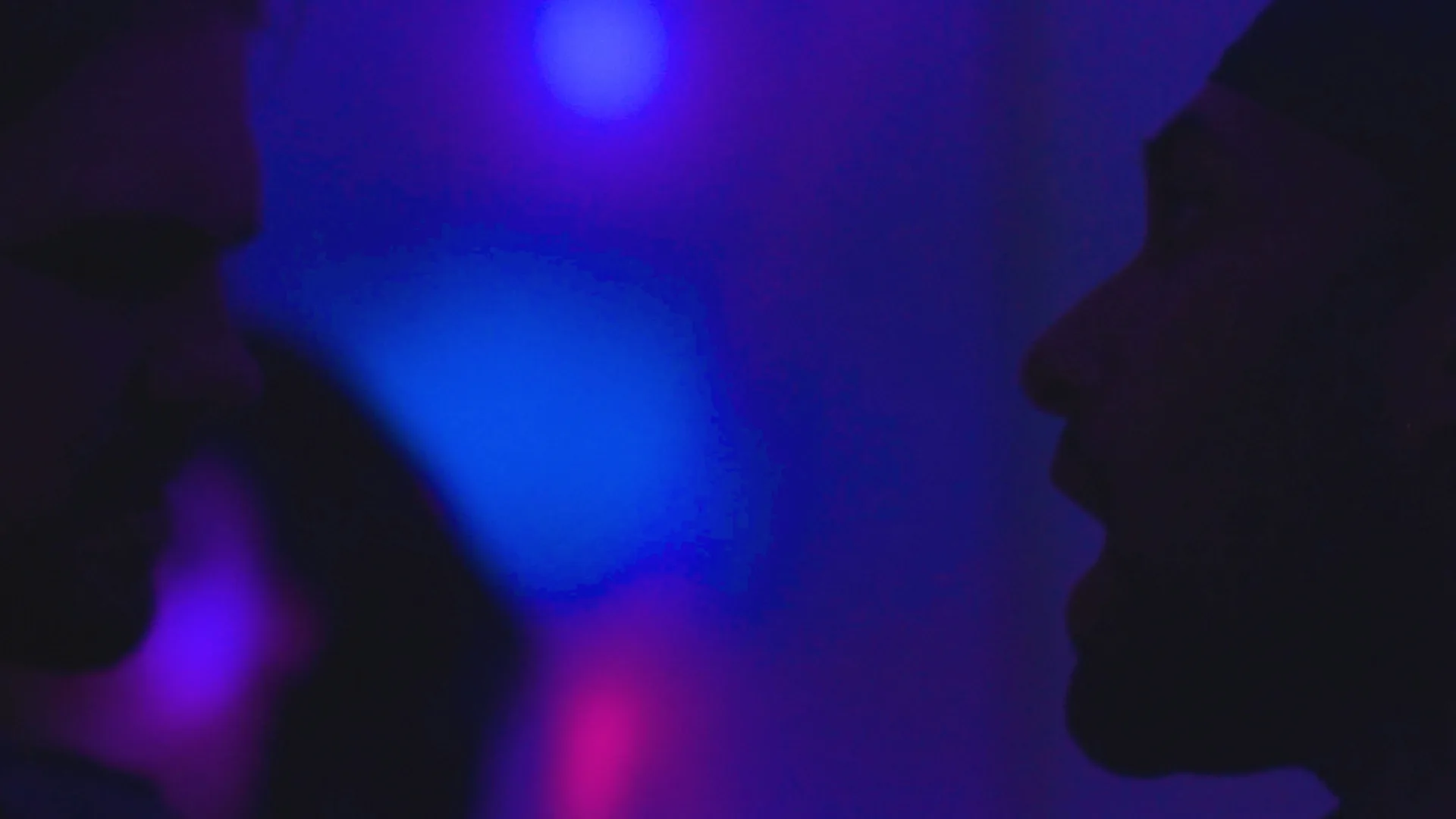 Nate and Jamie silhouetted in coloured light