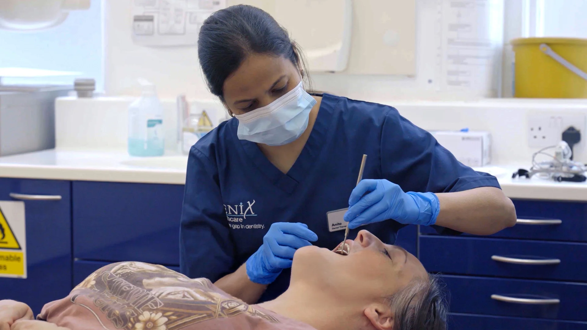Genix Healthcare clinician preparing dental equipment during treatment