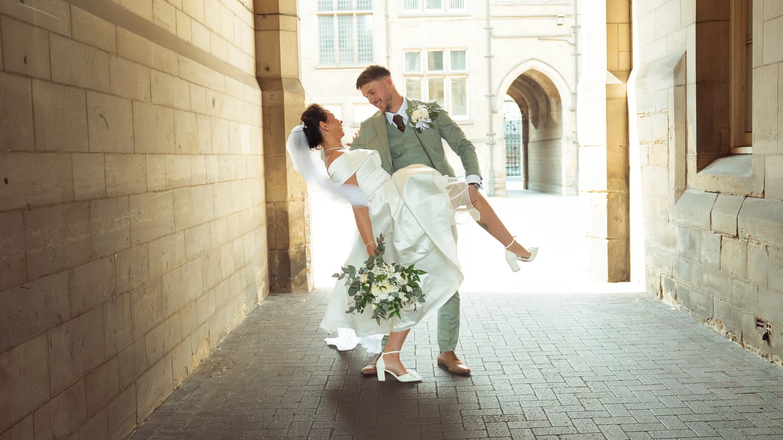 Ferguson and Howes wedding couple beneath a stone arch