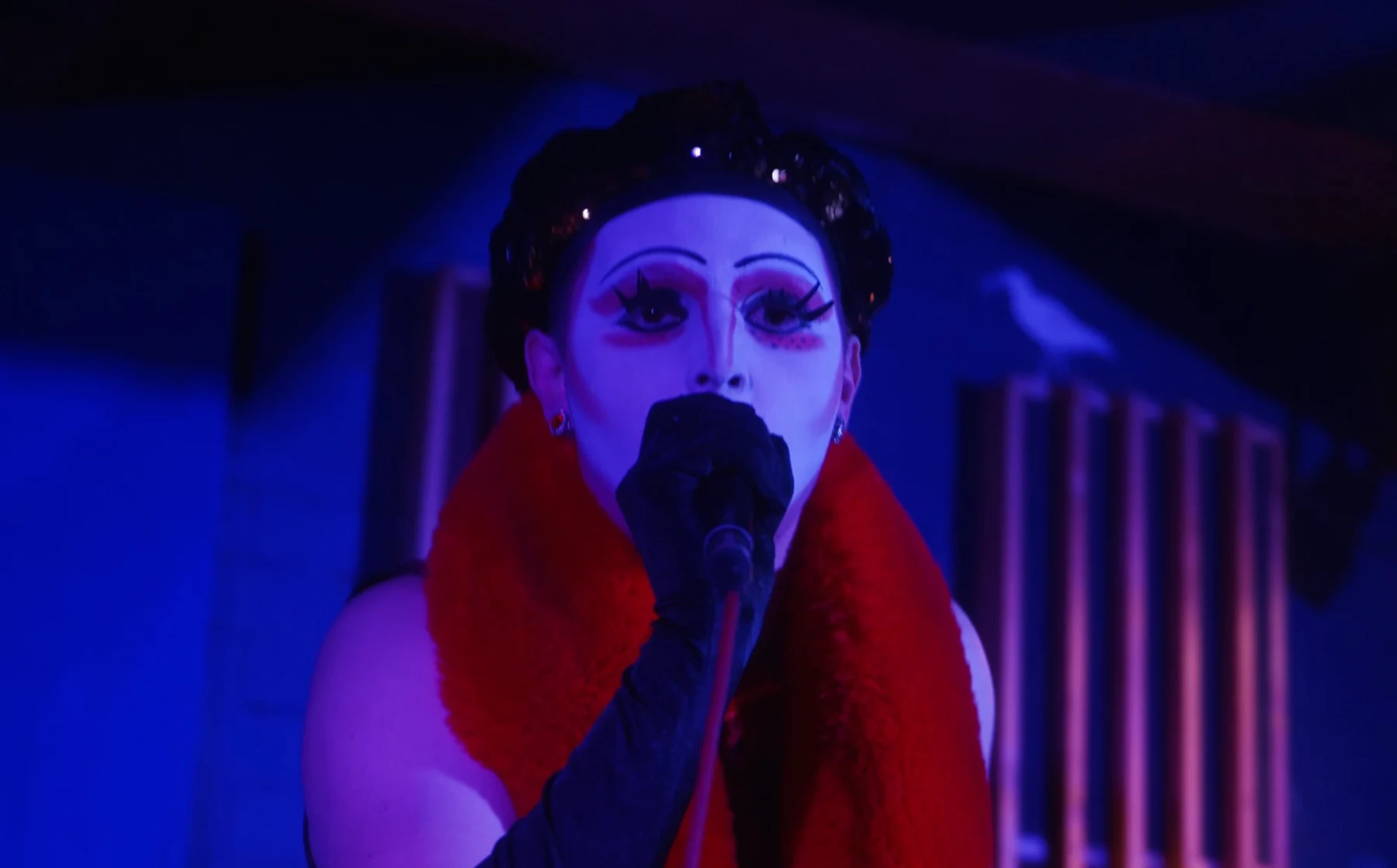 Pop Tartt performing in theatrical make-up and a red scarf