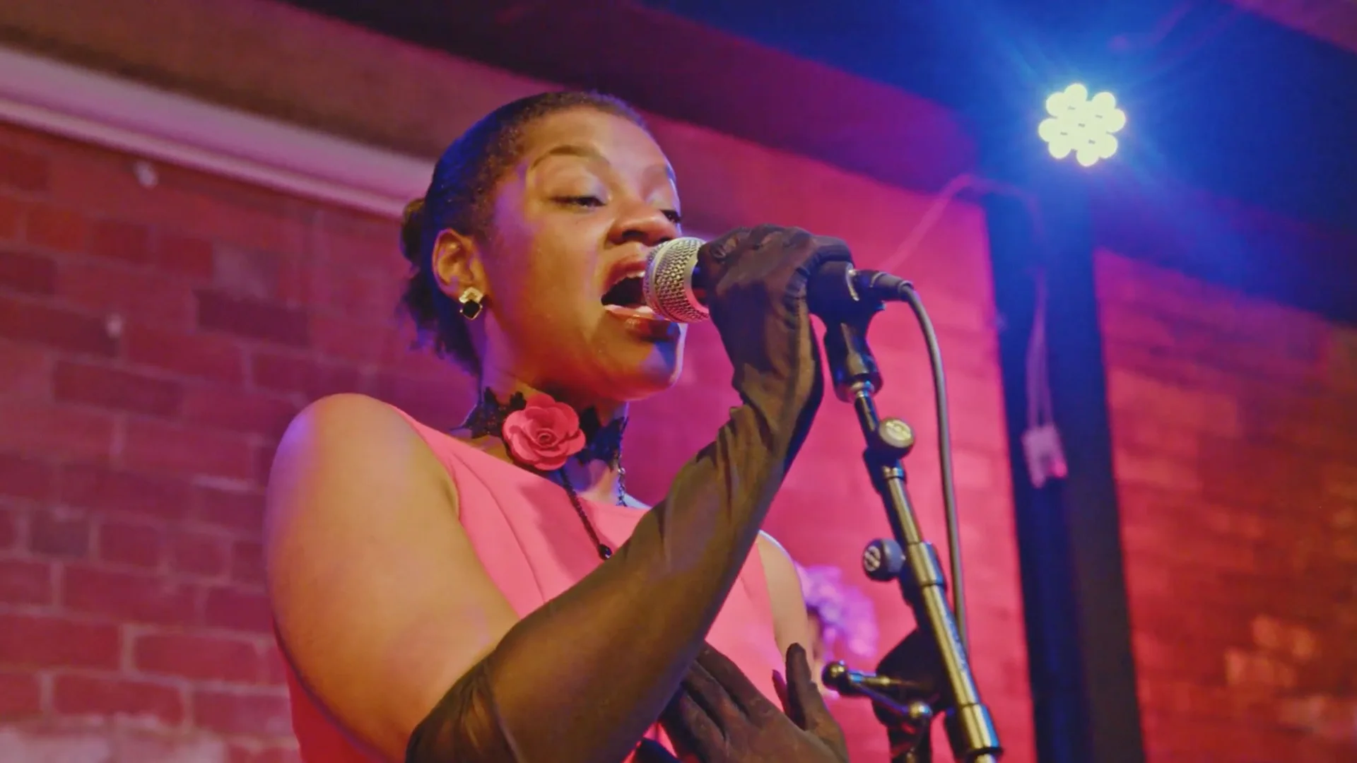 Vocalist in a pink dress performing at The Showcase