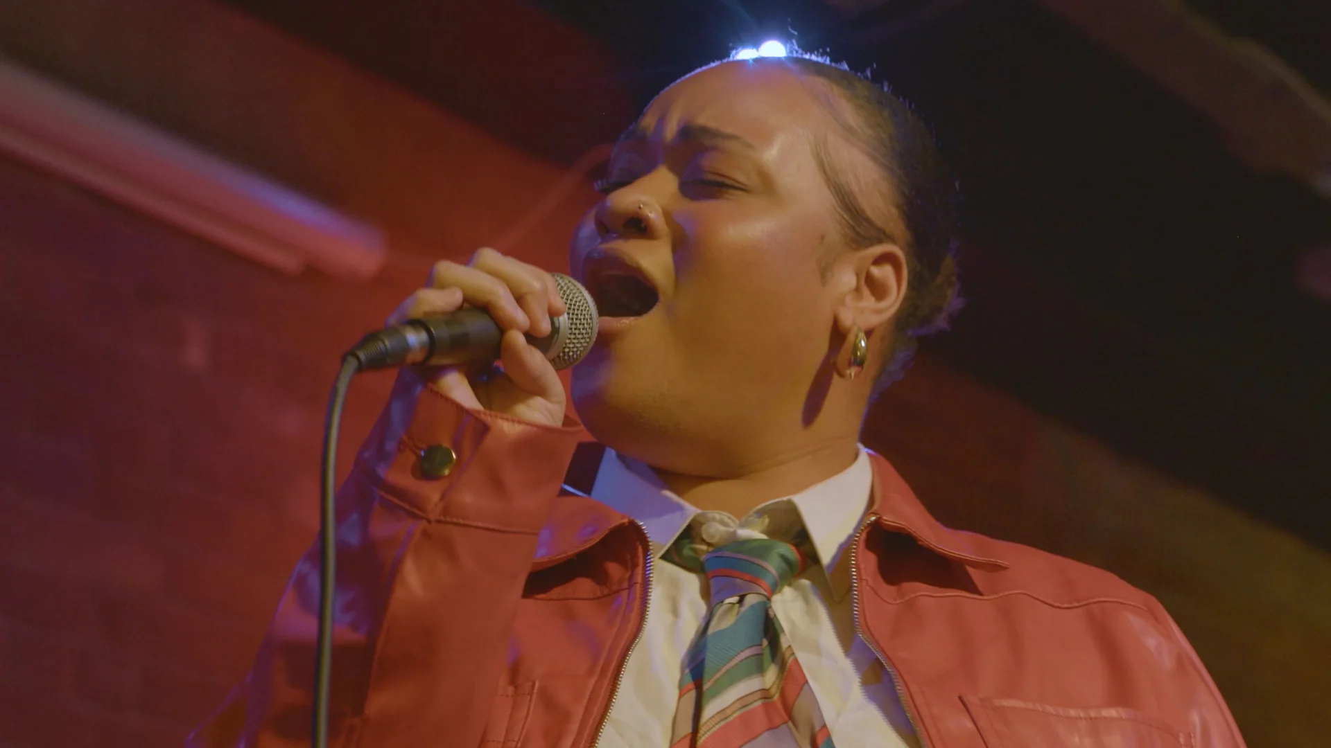 Singer performing in a shirt and tie at The Showcase