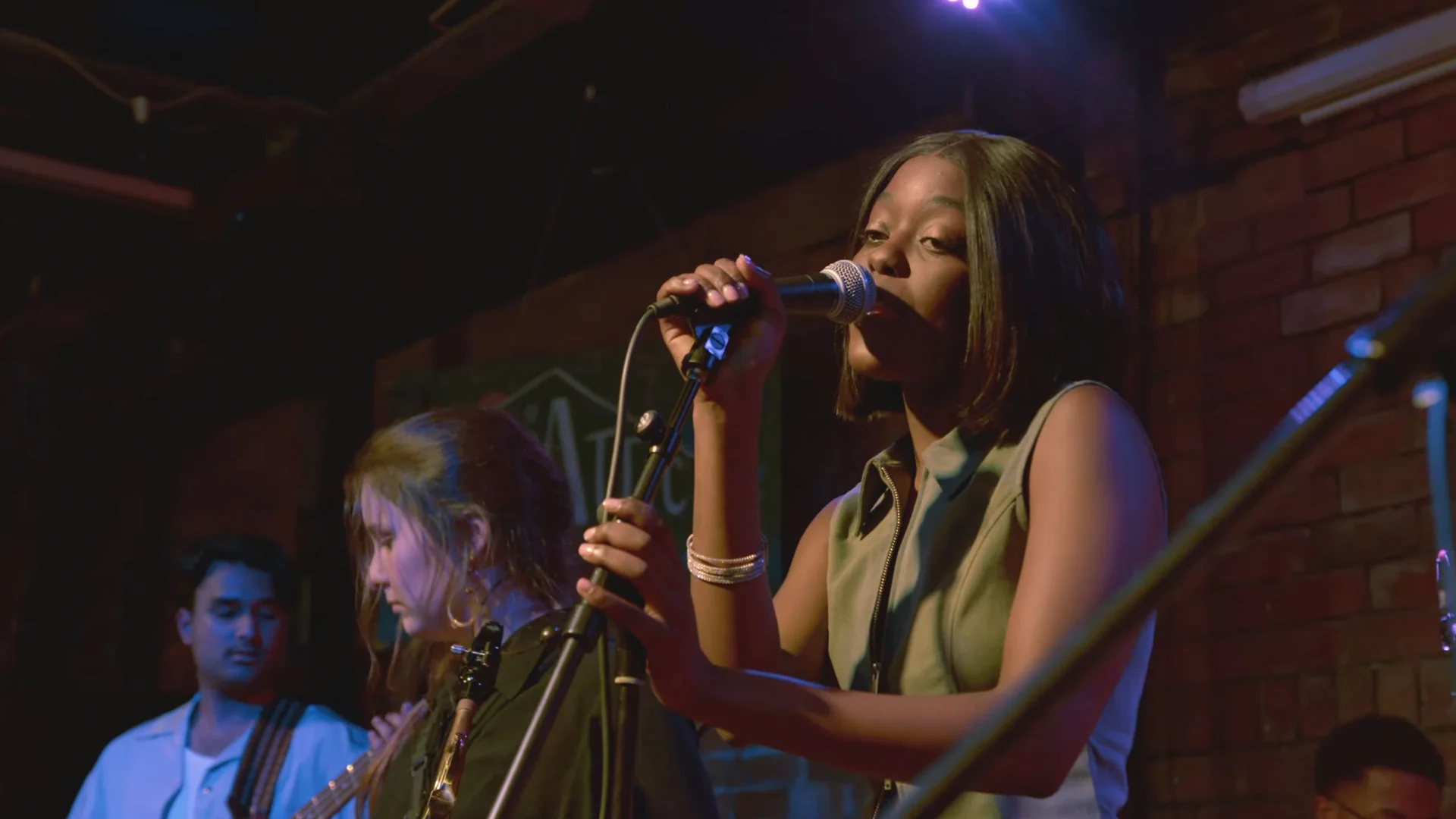 Vocalist performing beside the horn section at The Showcase