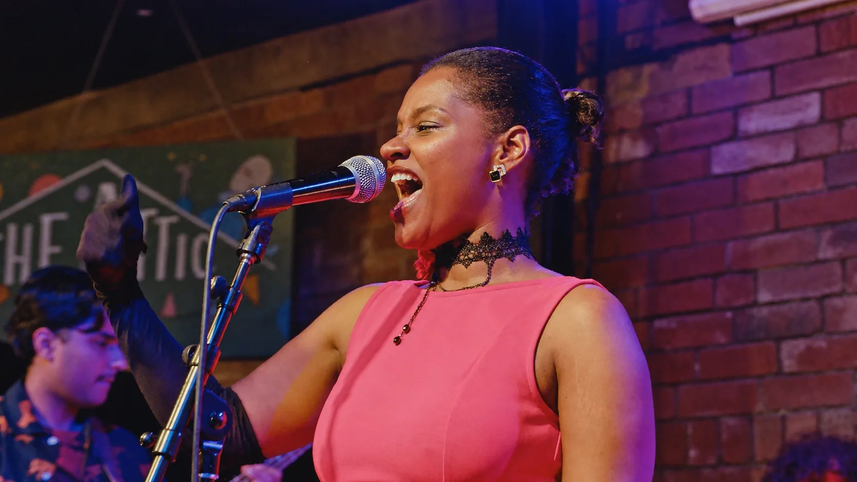 Singer performing in a pink dress at The Showcase