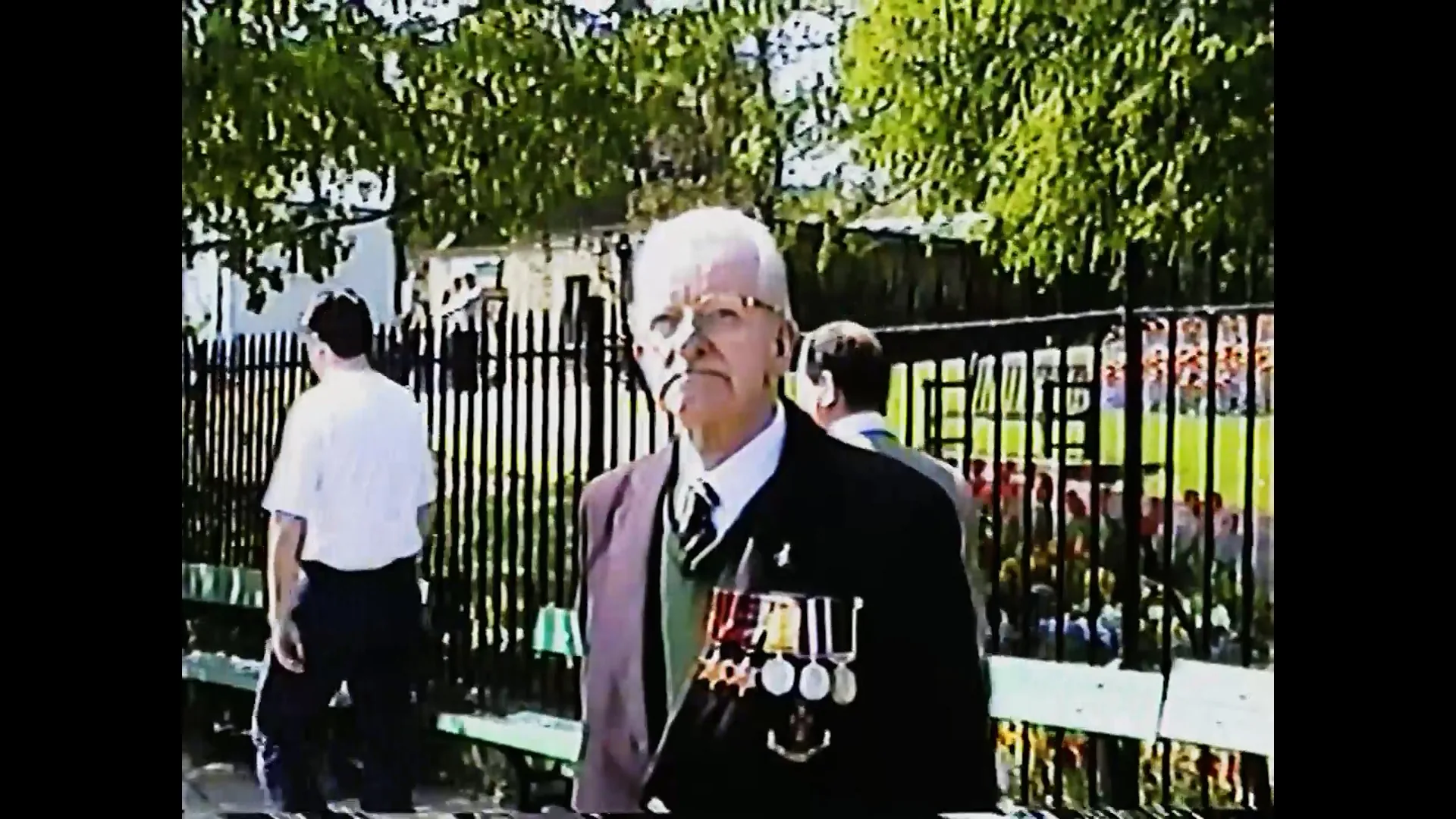 Original VHS tape ingest showing a veteran standing beside a park fence