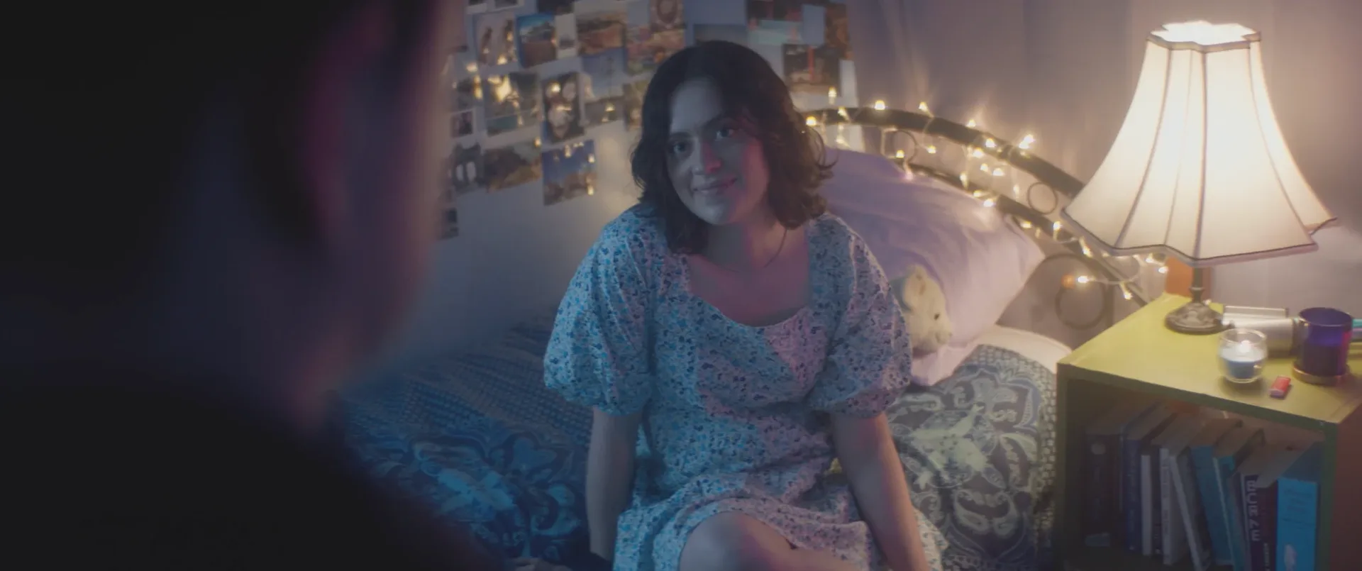 I’m Not Finished film still of a woman sitting on a bedroom floor beside warm lights